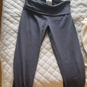 Grå yoga pants från Gina Tricot strl S  - Säljer ett par svarta leggings från Gina Tricot med bred midja och tight passform. Perfekta för en chill look eller till träning. Mjukt och stretchigt material som sitter skönt hela dagen.