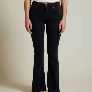 Svarta bootcut flare jeans - Snygga svarta jeans med bootcut och flare, låg midja och klassisk femficksdesign. Jeansen har en stilren look och är perfekta för dig som gillar en trendig siluett. Materialet är mjukt och stretchigt för extra komfort.