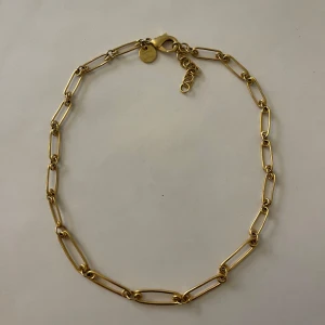 Guldfärgat halsband Sophie by Sophie - Klassiskt halsband från Sophie by Sophie i guldfärg med avlånga, rektangulära länkar. Kedjan har en karbinhake och justerbar längd med extra ringar. ✨ Tyvärr finns inte originalförpackningen kvar, men skickas i en annan smyckespåse. 