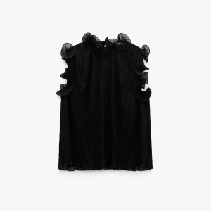 Svart volangblus Zara  - Supersnygg svart blus med plisserat tyg och volangdetaljer längs axlar och hals. Fråga för fler bilder. Säljer för att den inte kommer till användning. 