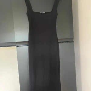 Svart klänning med breda axelband - En stilren svart långklänning från Zara med breda axelband och fyrkantig ringning. Klänningen är i bomull och  har en tight passform. Köparen står för frakt 💕