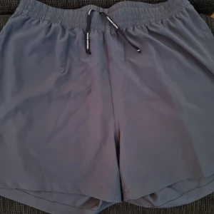 Mörkblå shorts från Panos Emporio - Snygga mörkblå shorts från Panos Emporio med elastisk midja och svart snörning med logga. Klassisk PE-logga på benet. Lätta och snabbtorkande, perfekta för stranden eller poolen. Enkel och stilren design som funkar till allt.