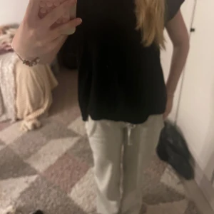 Svart t-shirt med öppen rygg - Svart t-shirt från H&M i mjuk bomull med korta ärmar och loose passform. Baksidan har coola slitningar som ger en öppen rygg-effekt. Perfekt för dig som vill sticka ut med en edgy vibe. En liten defekt vid nacken (se på sista bild)