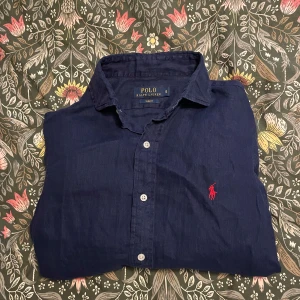 Ralph Lauren linneskjorta - Säljer en fet Ralph lauren linneskjorta i storlek S. Skjortan har lite längre armar en vanligt men har också krympt i tvätten så passar lite mer som XS! Lapparna är avklippta och därav ett billigare pris