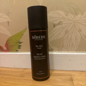 Nõberu Heat Protection spray 200ml - Värmeskyddsspray från Nõberu of Sweden, No 103 Amalfi. Kommer i en svart och brun flaska på 200 ml. Skyddar håret mot värme och bevarar färgen. Innehåller bland annat rosenvatten och solrosfröextrakt. Perfekt för dig som ofta stylar håret med värmeverktyg.