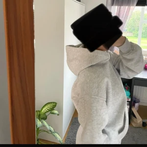 Ljusgrå hoodie - Rymlig luva och stor ficka framtill. Mjuk och skön