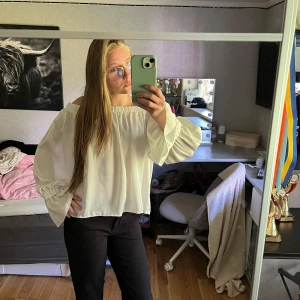 Vit offshoulder blus i XS - Säljer en superfin vit offshoulder blus med vida, långa ärmar och resår vid axlarna. Blusen har en luftig och flowy passform som ger en chill vibe. Perfekt att styla med jeans eller kjol för en trendig look.