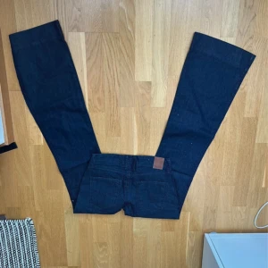 Mörkblå bootcut jeans från Replay - Väldigt snygga mörkblåa lågmidjade jeans. Passade tyvärr inte mig, lapp sitter kvar. Coola detaljer såsom fickorna, broderingen på bakfickorna samt knappen på framsidan. Innerbenslängd : 87-8. Storlek Xs. Passar långa tjejer. Man kan sprätta upp där nere ca 5cm. Helt perfekta jeans! 