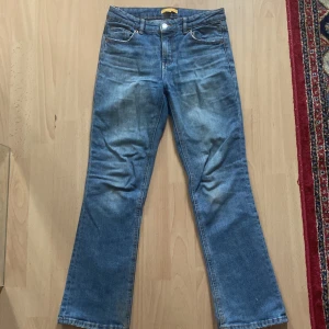Blå bootcut low waist jeans från Gina Tricot - Snygga blå jeans från Gina Tricot, modell Perfect Jeans. Klassisk femficksdesign, bootcut-ben och normal passform. Jeansen är i ett mjukt denimtyg och har en tidlös blå tvätt. 