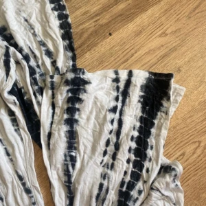 Svarta och vita tie-dye wide byxor - Säljer ett par riktigt sköna wide byxor med svart och vit tie-dye mönster. Byxorna har hög midja med resår och är tillverkade i mjukt bomullstyg. Perfekta för en chill och avslappnad stil. Funkar även på s