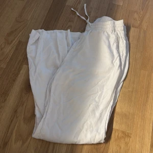 Vita mjukisbyxor med snörning - Säljer ett par vita mjukisbyxor med elastisk midja och snörning. Byxorna har en avslappnad passform och är perfekta för chill dagar hemma eller när du vill vara bekväm. Gjorda i mjukt material för extra komfort.