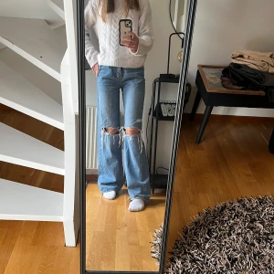 Blå wide jeans med slitna knän - Säljer ett par blå jeans med vida ben och stora slitningar över knäna. Köpta på Ginatricot för 599 och är i bra skick✨