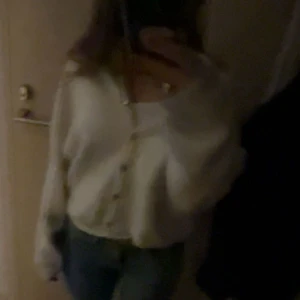 Krämvit kofta  - Supermjuk och fluffig krämvit kofta från Gina med pärlemorknappar. Koftan har en loose fit, långa ärmar och ribbade muddar. Perfekt att slänga över en topp för en chill och snygg look.