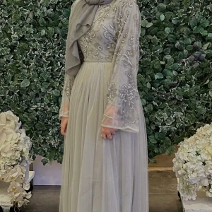 Ljusgrå långklänning med broderier - Superfin ljusgrå långklänning köpt från boohoo. Endast använd en gång och är i väldigt bra skick 