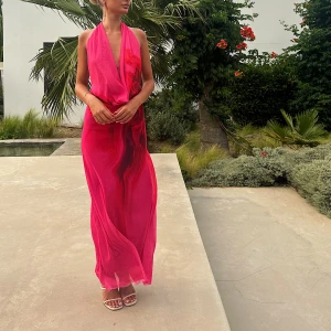 Rosa långklänning från Zara XS - Säljer en maxiklänning från Zara i stark rosa med röda detaljer. Klänningen har halterneck, öppen rygg och ett snyggt draperat fall. Storlek är xs men passar mig som är en storlek s i vanliga fall. Använd en gång för att fota i 