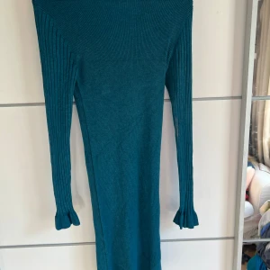 Turkos ribbad långärmad klänning Amisu - Säljer en turkos ribbad långklänning från Amisu. Klänningen har långärmade ärmar med lätt utsvängda muddar och en tight passform. Materialet är mjukt och stretchigt, perfekt för dig som gillar en enkel men snygg look.