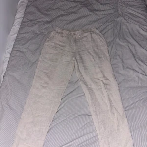 Beige linnebyxor från AKRYL - Säljer ett par ljusbeige linnebyxor från AKRYL i storlek S. Byxorna har elastisk midja med snörning och raka ben, perfekta för chill dagar. Luftigt material i linne som ger en avslappnad vibe. 100% Linne , pris diskuterbart