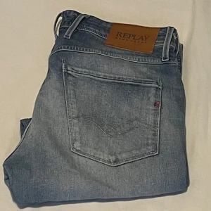 Replay Anbass ljusblå jeans med slitningar - Säljer ett par Replay Anbass jeans i ljusblå tvätt med slitningar och snygga detaljer. Klassisk femficksmodell med snygga detaljer på bakfickorna. Jeansen har en slim passform och är tillverkade i mjukt bomullsjeansmaterial.