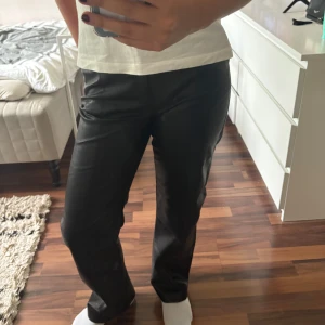 Svarta raka byxor i skinnimitation - Säljer ett par svarta byxor i skinnimitation med rak passform som aldrig är använda💗