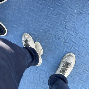 Saint lauran skor i ny condition - Snygga vita sneakers med svarta skosnören och klassisk rund tå. Skorna har en platt sula och är perfekta för en avslappnad streetstyle-look. Passar till det mesta och ger en cool vibe till outfiten.