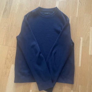 Mörkblå stickad tröja Jack & Jones - En stilren mörkblå stickad tröja från Jack & Jones Premium. Tröjan har rund halsringning, långa ärmar och en klassisk passform. Perfekt för dig som gillar en enkel och clean look till höst och vinter.