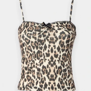 Leopardmönstrad linne från Gina Tricot - Säljer ett leopardmönstrat linne från Gina Tricot med tunna axelband och liten svart rosett framtill. Toppen har spetskant upptill och är i mjukt, stretchigt material. Perfekt för dig som vill sticka ut med ett djurmönster och cool vibe.