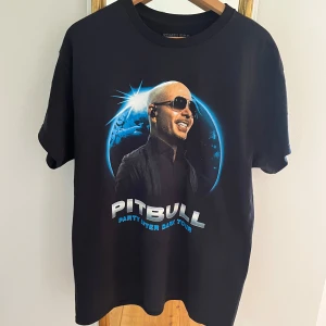 Pitbull Party After Dark Tour merch t-shirt - Funderar på att sälja denna t-shirt köpt som merch under pitbulls konsert nu i Stockholm den 29/6, då jag även köpte annan merch och inte är i behov av denna. I strl L, sitter oversize på mig som vanligtvis brukar ha S. Fortfarande i nyskick. Inte helt säker på att jag vill sälja dock, så hör av dig vid intresse! Köpt för 500 kr