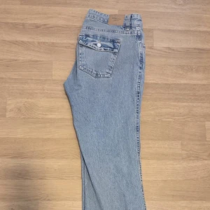 Ljusblå y2k low bootcut jeans från Ginatricot  - Säljer ett par ljusblå y2k low bootcut jeans från Gina i storlek 42. Säljer de då de är för stora för mig. Använt de bara en gång så de är relativt nya. Köpte de för 499kr och säljer de för 300kr
