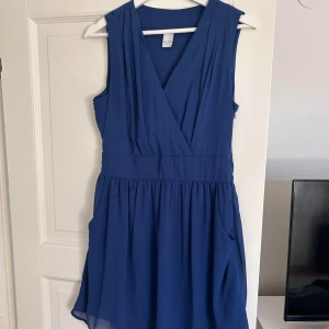 Marinblå klänning  - Knappt använd. Har fickor och dragkedja på sidan. 