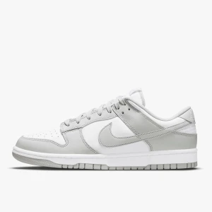 Nike Dunk Low vit/grå sneakers - Nike Dunk Low sneakers i vitt och ljusgrått skinn, ifrån Zalando. Klassisk siluett med snörning, rund tå och platt sula. Perfekt för dig som gillar stilrena och cleana sneakers med retrovibbar. Säljer på grund av att de är för små för mig.