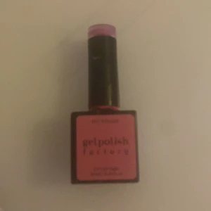 Gelpolish Factory Ken's Girlfriend - Säljer ett nagellack från Gelpolish Factory i färgen Ken's Girlfriend. Färgen är en stark, Barbie-inspirerad rosa och flaskan är fyrkantig med svart och rosa detaljer. Perfekt för dig som vill ha riktigt poppiga naglar.