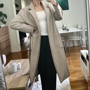 Beige kappa - Beige kappa från Gina Tricot i storlek 34, passar runt S. Lite smått nopprig vid insidan av armen men syns inte så mycket (se bild), annars fint skick! Rabatt om ni gör en bundle, så kika in min profil om ni hittar något mer!☀️