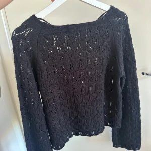 Svart stickad tröja Vero Moda M - Svart stickad tröja från Vero Moda i storlek M. Tröjan har ett snyggt hålmönster, båtringad hals och långa ärmar. Perfekt för lager-på-lager och funkar till både jeans och kjol. Mjuk och skön känsla med en lite loose passform. Aldrig använd säljer matchande skjol!!!