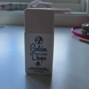 W7 Golden Glow Drops bronzer - Golden Glow Drops från W7 är flytande bronzerdroppar i en smidig plastflaska med skruvkork. Ger en varm, gyllene ton och glow till huden. Perfekt att blanda i foundation eller använda direkt på huden för en solkysst look. Vegansk och lätt att applicera. Mycket kvar! 