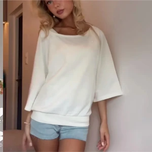 Vit loose sweatshirt med trekvartsärm - Enkel och stilren vit sweatshirt med loose passform och trekvartsärmar. Tröjan har bred mudd nertill och en rundad halsringning. Perfekt för en chill och avslappnad look.