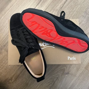 Christian Louboutin svarta - Svarta sneakers från Christian Louboutin i lyxig mocka med klassisk röd sula och diskret logga. Skorna kommer med kartongen. Storlek 40 men är lite större i storleken