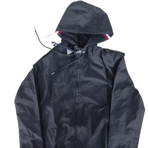 Moncler windbreaker - Svart vindjacka från Moncler med huva och dragkedja framtill. Jackan har en enkel, stilren design med diskreta detaljer och är perfekt för blåsiga dagar. Lätt material som känns smidigt och bekvämt. Snygg detalj med Moncler-logga på insidan av huvan. Finns några repor på högra axeln