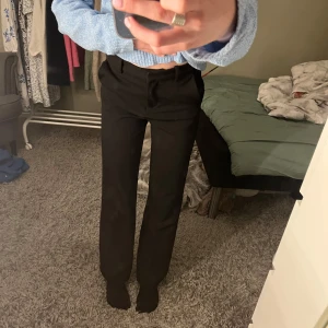 Svarta kostymbyxor från Vero Moda - Säljer ett par svarta kostymbyxor från Vero Moda!!🤗Byxorna har hällor för bälte och stängs med dragkedja och knapp. Det jag älskar med dessa byxor är att dem både går att klä upp och ner!! Dom är även av väldigt bra kvalitet! Hör av er om ni har några frågor eller vill ha fler bilder!🥰