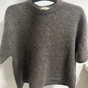 stickad kortärmad  - Mysig brun stickad tröja från & Other Stories med korta ärmar och rund hals. Perfekt för lager-på-lager och chill höst- eller vinterstil. Tröjan har en enkel, klassisk design och är supermjuk mot huden.