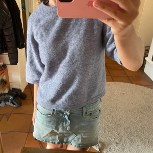 Grå stickad T-shirt  & Other Stories - En blå stickad T-shirt från & Other Stories med rund hals och halvlånga ärmar. Stickad T-shirt med skön passform och perfekt att styla med jeans eller kjol. Skön och ha nu en sommarkväll, den passar även andra årstider!🥰🥰 På bilden ser den lite grå ut men det är bara ljuset. Den är mer blå i verkligheten!