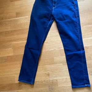 Mörkblå Lee jeans straight fit - Snygga mörkblå jeans från Lee med klassisk femficksdesign och raka ben. Jeansen har normal midja och Lee-läderpatch baktill. Perfekta för dig som gillar en tidlös och clean look.