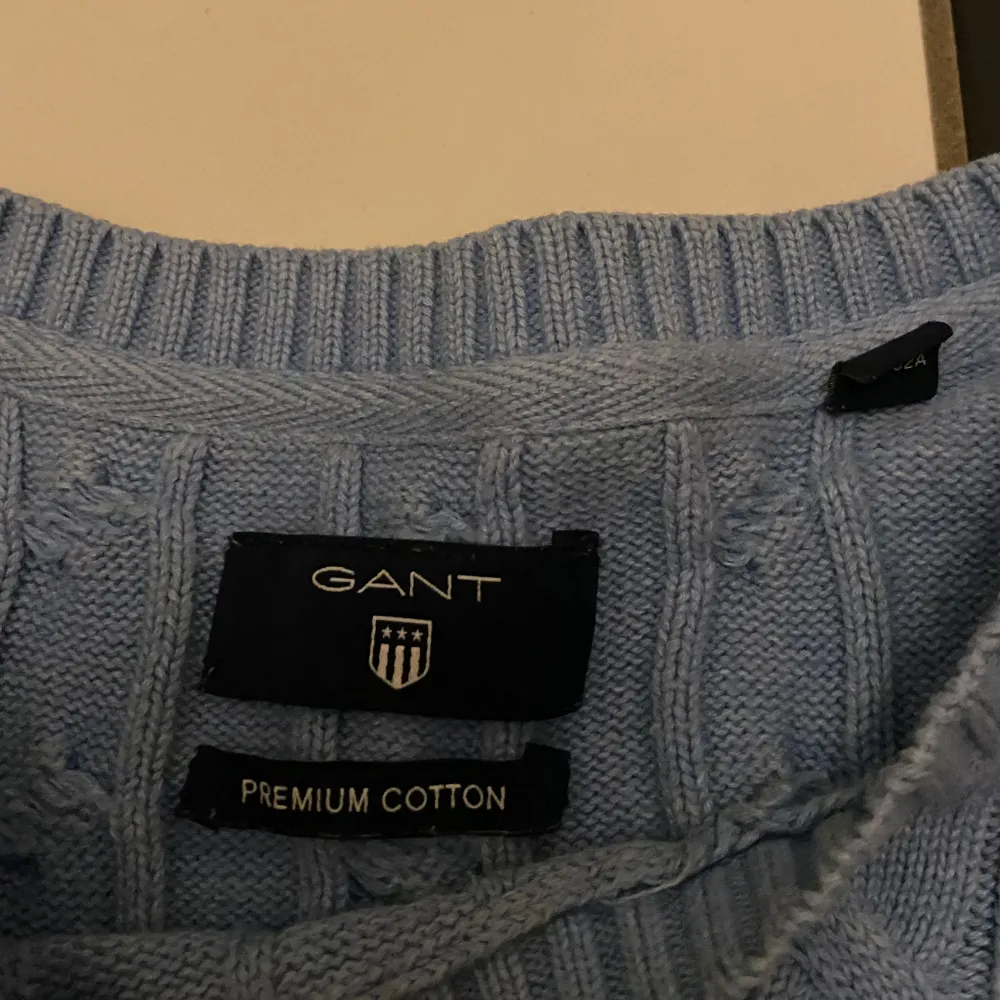 Säljer en stilren ljusblå kabelstickad tröja från GANT i premium bomull. Tröjan har en klassisk rund halsringning och långa ärmar. Perfekt för en avslappnad men ändå elegant look. 🧶 Storlek M men passar S. Neuletakit & Villapaidat.