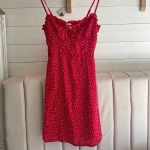 Röd prickig klänning från Princess Polly - Säljer en söt röd klänning med vita prickar från Princess Polly. Klänningen har smala axelband och volangdetaljer vid bysten. Perfekt för en somrig look! 🌸