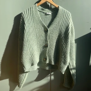 Grön kofta💚 - Säljer denna snygga gröna ribbade kofta från Chiquelle. Koftan har en lite oversized design med stora knappar framtill och långa ärmar.💚Perfekt för att hålla sig varm och stilren under kyligare dagar. Passar bra till både jeans och kjol💚