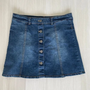 Jeanskjol med knappar - Snygg jeanskjol från Mywear Young med knappar framtill. Kjolen har en klassisk blå denimfärg och är i storlek 146/152 men passar även mig som har storlek xs/s. Perfekt för i sommar🩷