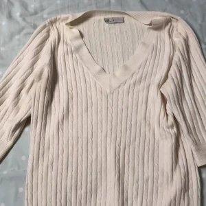 Vit ribbad tröja från H&M - Säljer en stilren vit ribbad tröja från H&M med v-ringad hals. Tröjan har trekvartsärmar och är perfekt för en avslappnad look. Passar bra till både jeans och kjol. Perfekt för vår och sommar!