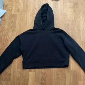 Svart croppad hoodie från Zara - Säljer en svart croppad hoodie från Zara. Den har en klassisk design med huva och långa ärmar. Perfekt för en avslappnad stil. Passar bra till jeans eller leggings.