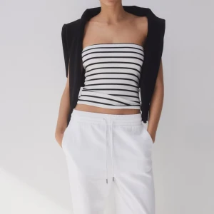 Randig tubtopp - Snygg randig tubtopp i svart och vit. Perfekt för en stilren look med en croppad passform. Passar bra till både jeans och kjol för en avslappnad stil.