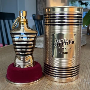 Jean Paul Gaultier Le Male Elixir - Säljer en lyxig parfymflaska från Jean Paul Gaultier, Le Male Elixir. Flaskan har en unik design i form av en manlig torso med guld- och svartfärgade ränder. Den kommer i en matchande metallcylinder med samma färgtema. Det är en mycket söt och kryddig parfym som har noterna honung, tobak, vanilj och lavendel. Jag säljer den här parfymen för att jag inte riktigt gillade doften på min hud. Nästan Oanvänd, det finns cirka 95% kvar. 75 ml stor flaska. Nypris 860kr. Frakt inkommer!