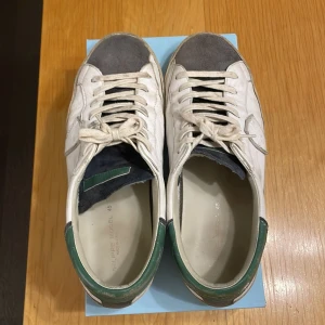 Philippe Model Prlu - Snygga Philippe Model sneakers i använt skick som skulle behöva ha sig en tvätt men väldigt bra skick ändå. Det negativa är väll att under sulan så är det lite slitet, se bild. Köpta nya för 4500kr och vill bli av med då dem inte används. Storlek 45 men passar 44 med då dem är lite små i storlek. Orginalbox medföljer. Billigare vid snabb och smidig affär. Skriv för frågor:)